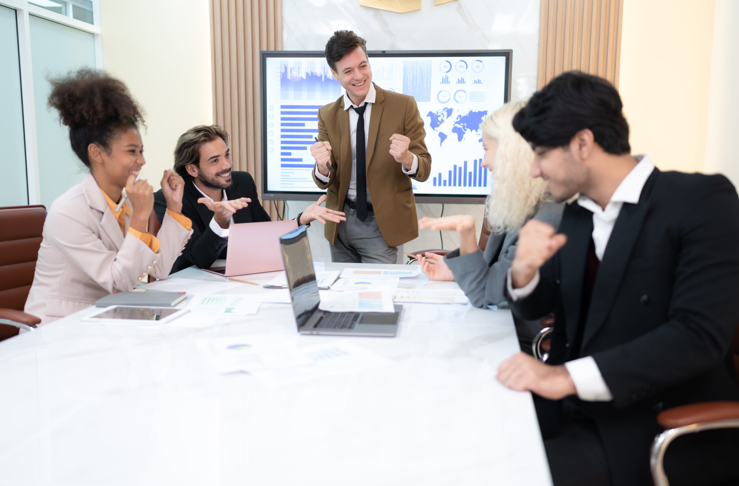 In the meeting room of an international business corporation, a diverse group of young entrepreneurs are enthusiastically taking their ideas and sharing perspectives.